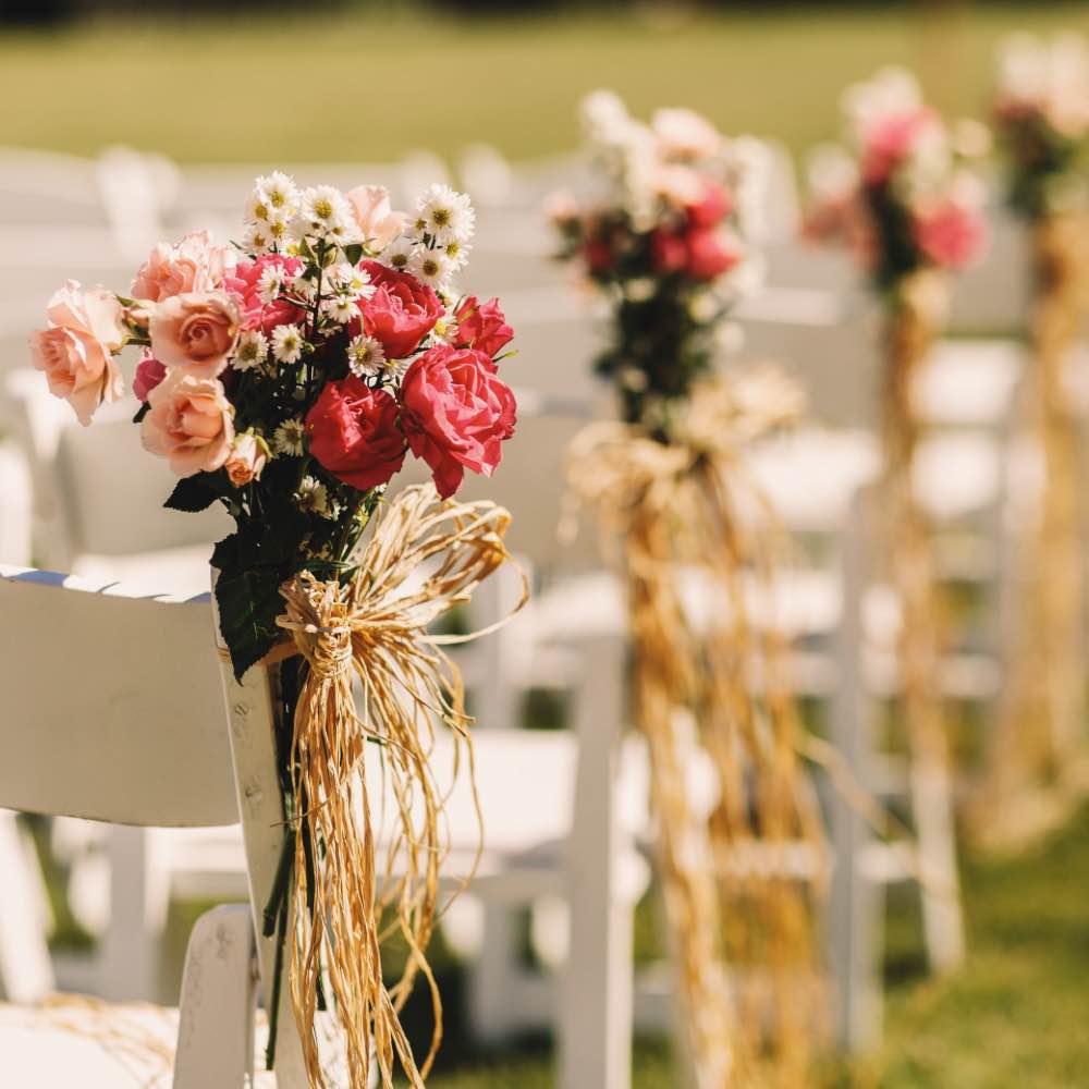 Stole rækker med lyserøde blomster sat op til bryllup